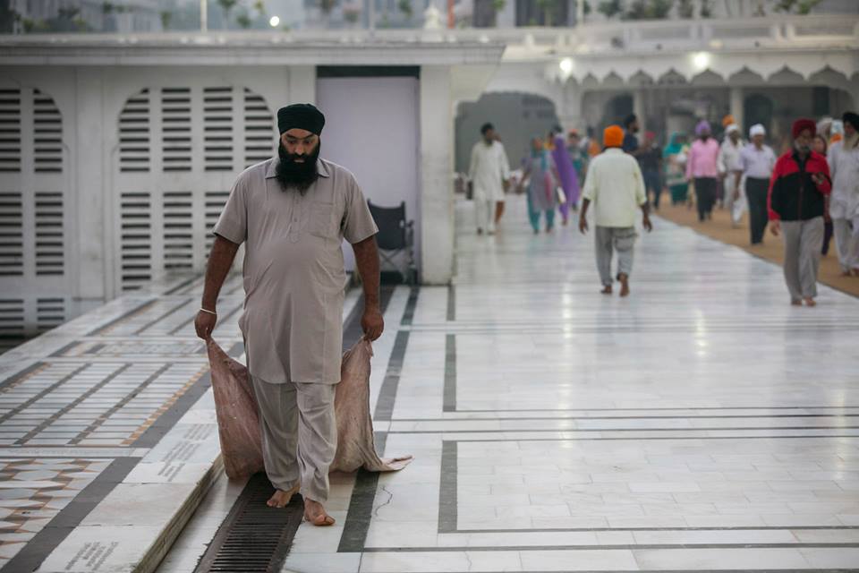 A volunteer cleaning the wet sides and walk way with the cloth.
