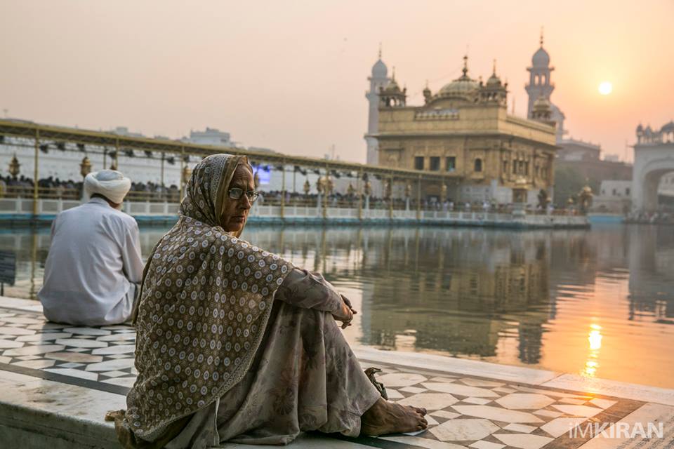 a mother waiting for her family beside the holy pool of Amritsar.