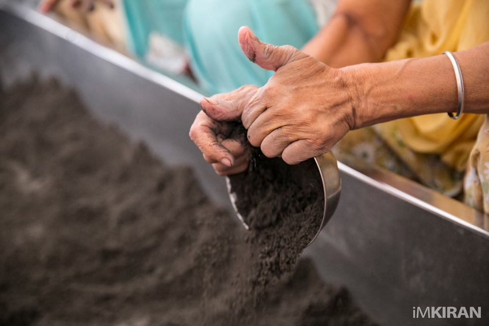 Volunteers washing the dishes with ash, according to the volunteers it makes the dishes holi and pure