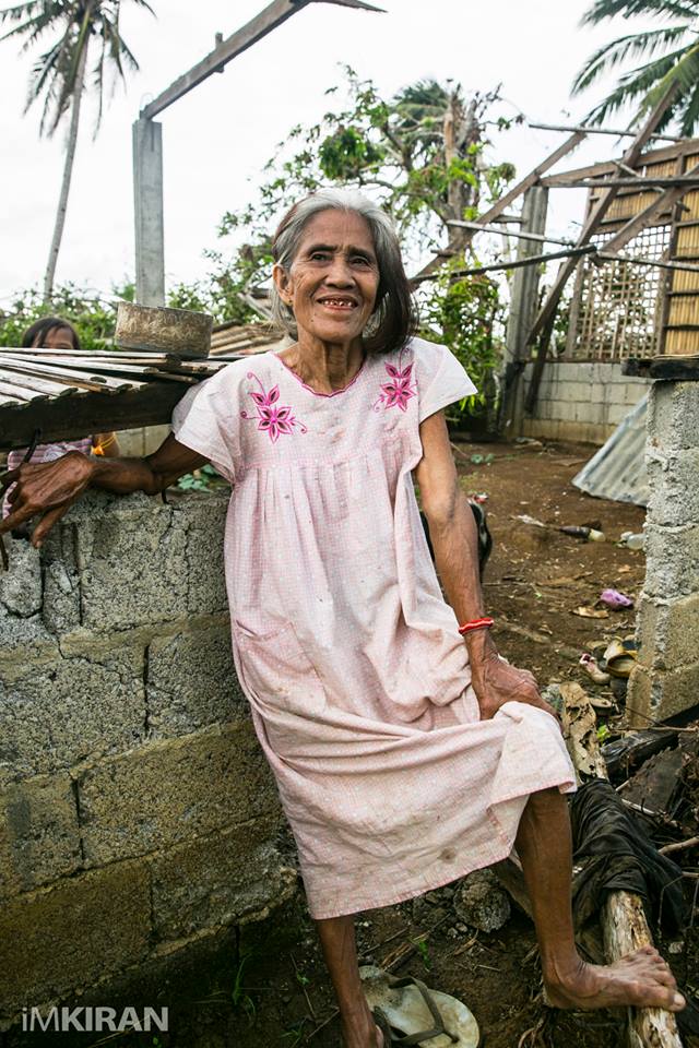 She had a funny smile and many teeth missing, still she walked up to her used to be home and got ready for this shot. Even asking me how do I stand. — in Panay, Philippines