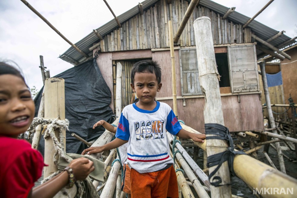 Boy stand in front of the house which was newly build after the typhoon. I wondered will it last the next typhoon..