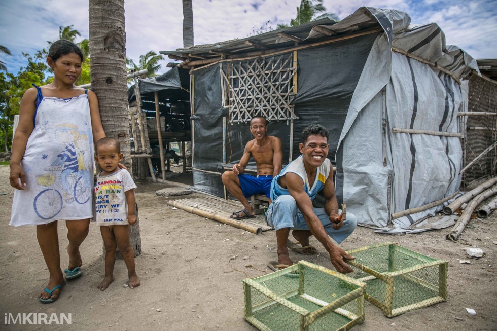 Locals getting ready the fishing traps. In the background is another put together shelter. - Baliguian Island, Panay - Philippines